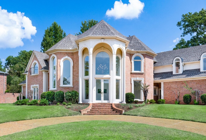 French country home with french doors, a front lawn, and brick siding