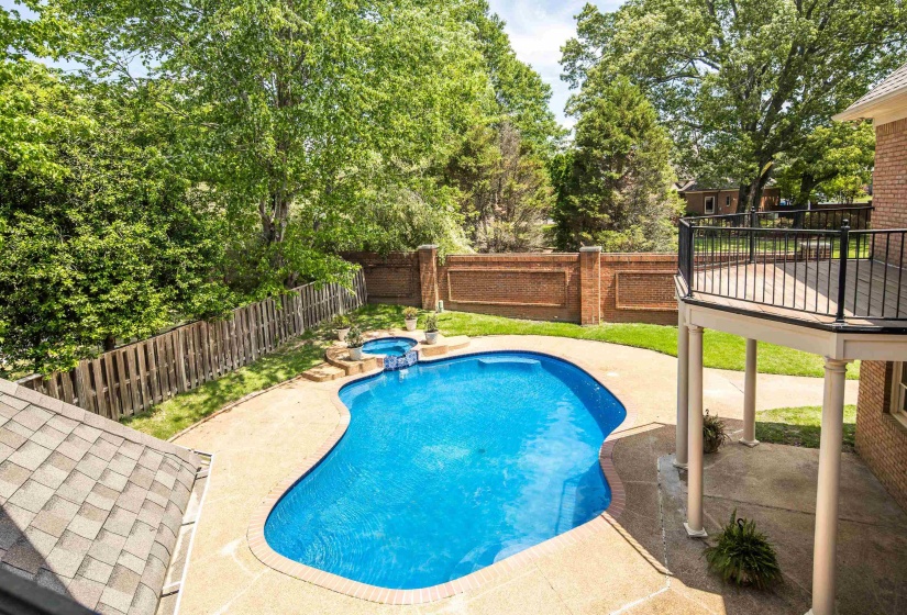 View of swimming pool with a fenced backyard, a pool with connected hot tub, a patio, and view of wooded area