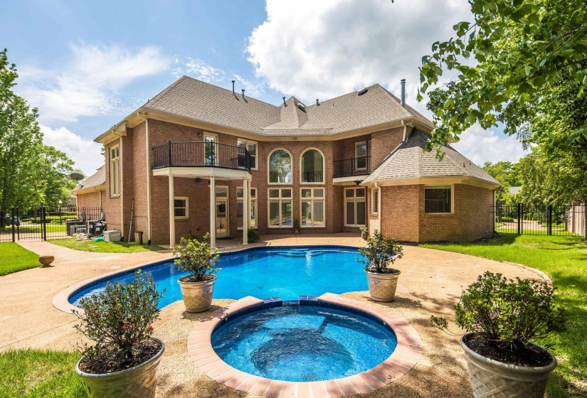 View of pool with a patio, fence, and a pool with connected hot tub