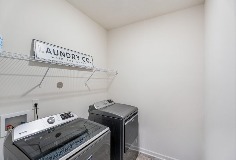 Clothes washing area with washing machine and dryer and baseboards