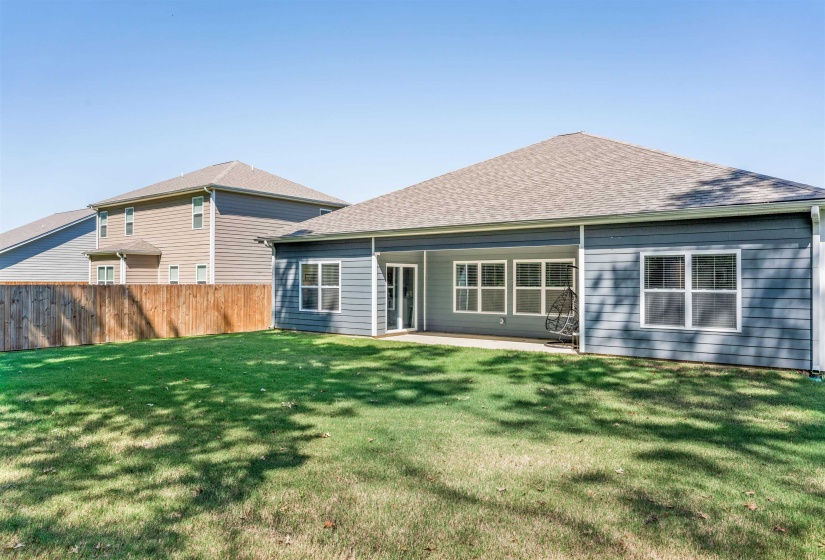 Rear view of house with a shingled roof and a patio