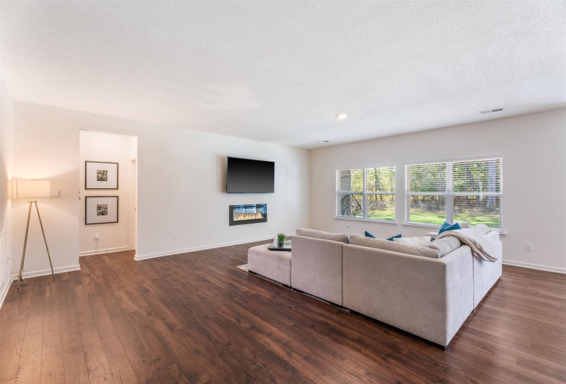 Living room with dark wood-type flooring, baseboards, and a textured ceiling