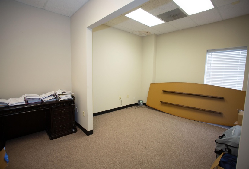 Carpeted home office with a paneled ceiling