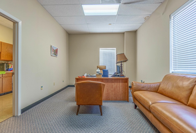 Carpeted office space featuring a paneled ceiling