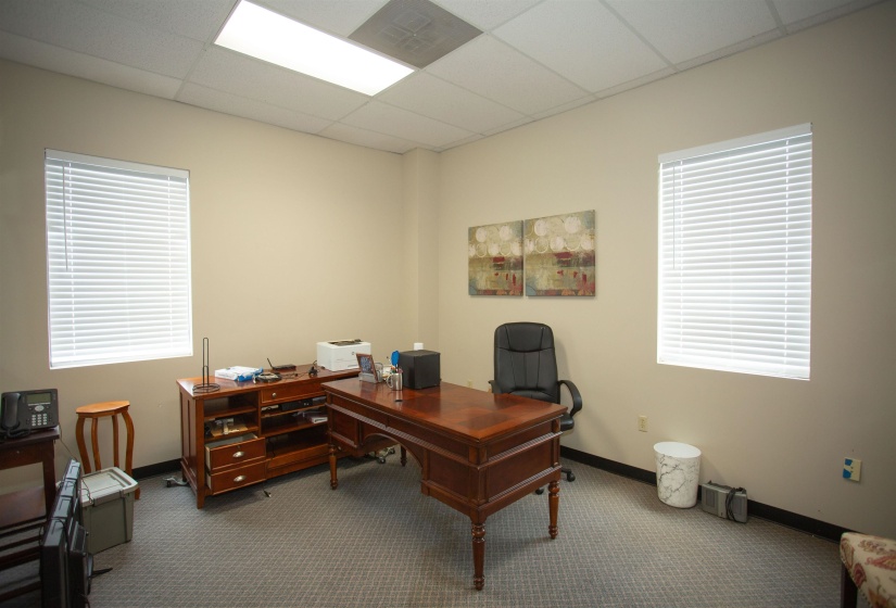 Office space with a drop ceiling and carpet flooring