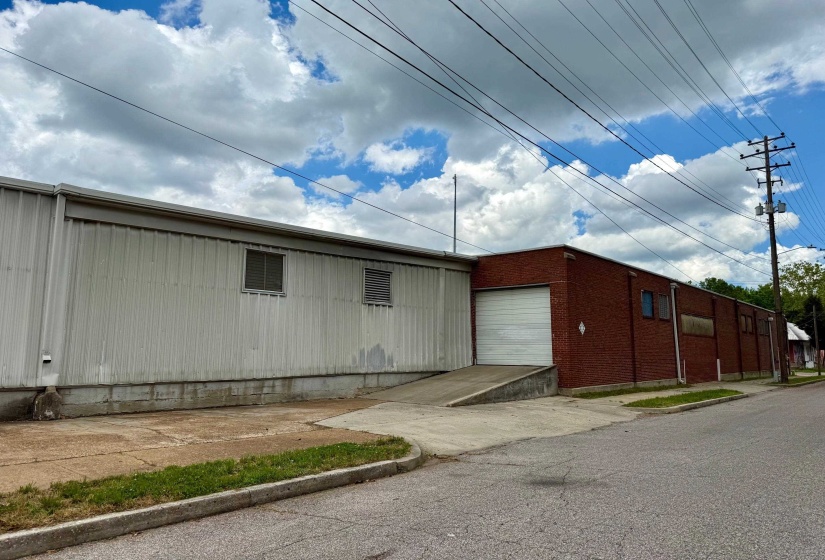 View of building exterior featuring concrete driveway and a garage