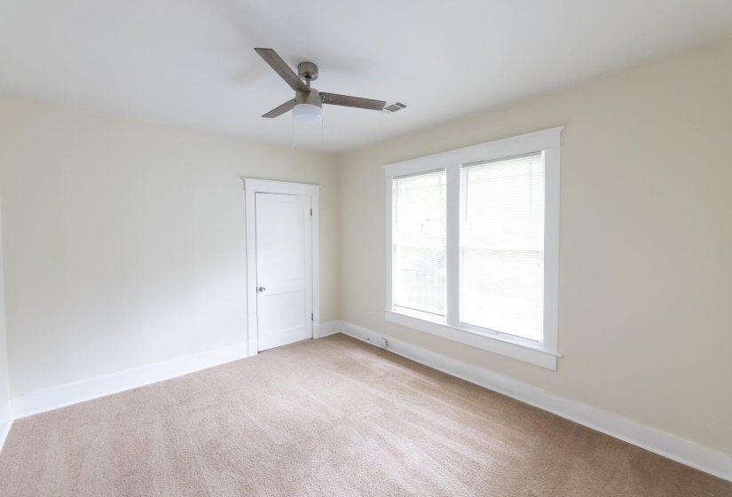Carpeted empty room featuring ceiling fan