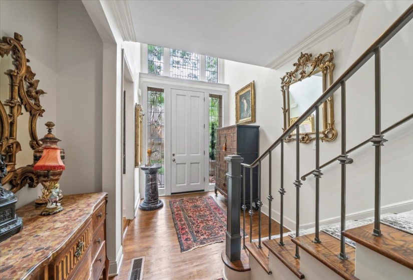 Foyer with wood finished floors, stairway, crown molding, and baseboards