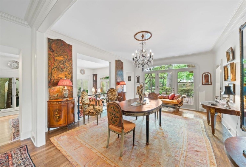 Dining space with wood finished floors, a chandelier, and ornamental molding