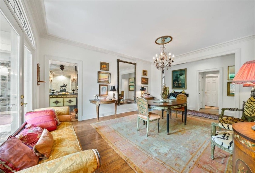Dining room with a chandelier, ornamental molding, and wood finished floors