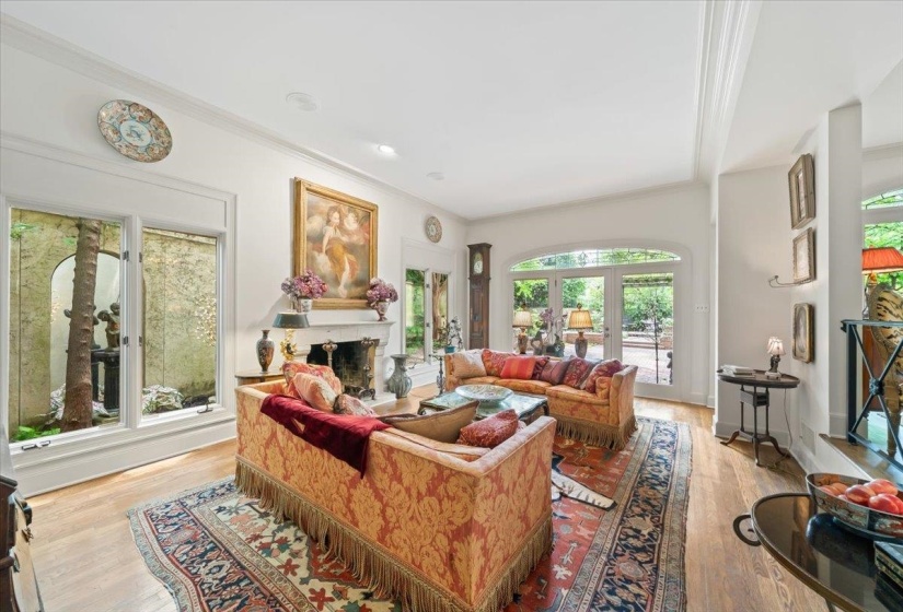 Living room featuring ornamental molding, a fireplace, and light wood finished floors