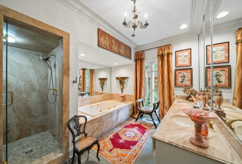 Bathroom with crown molding, a shower stall, a soaking tub, a chandelier and double vanity