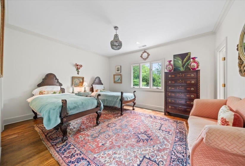 Bedroom with crown molding, wood finished floors, and baseboards