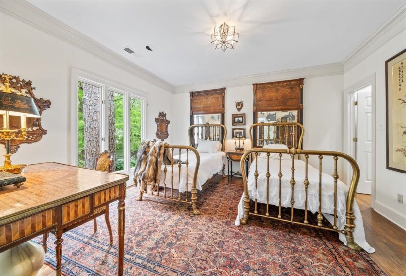 Bedroom with wood finished floors, crown molding, and baseboards