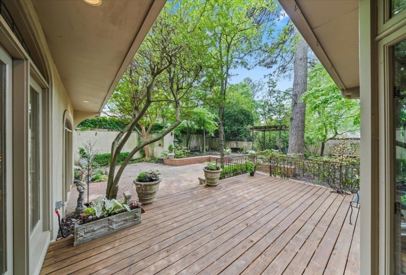 Wooden deck with a fenced backyard and a patio