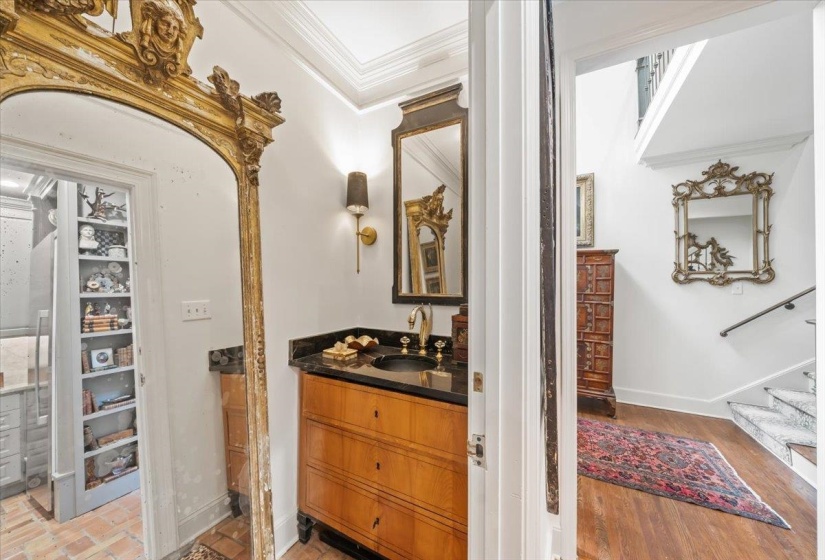 Bathroom featuring crown molding, baseboards, vanity, and wood finished floors
