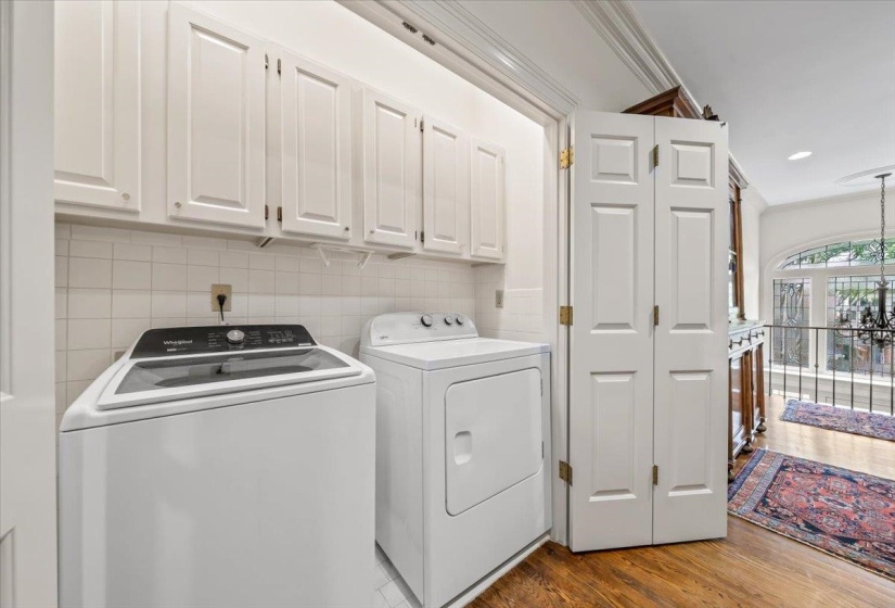 Clothes washing area featuring cabinet space, washer and clothes dryer, and wood finished floors