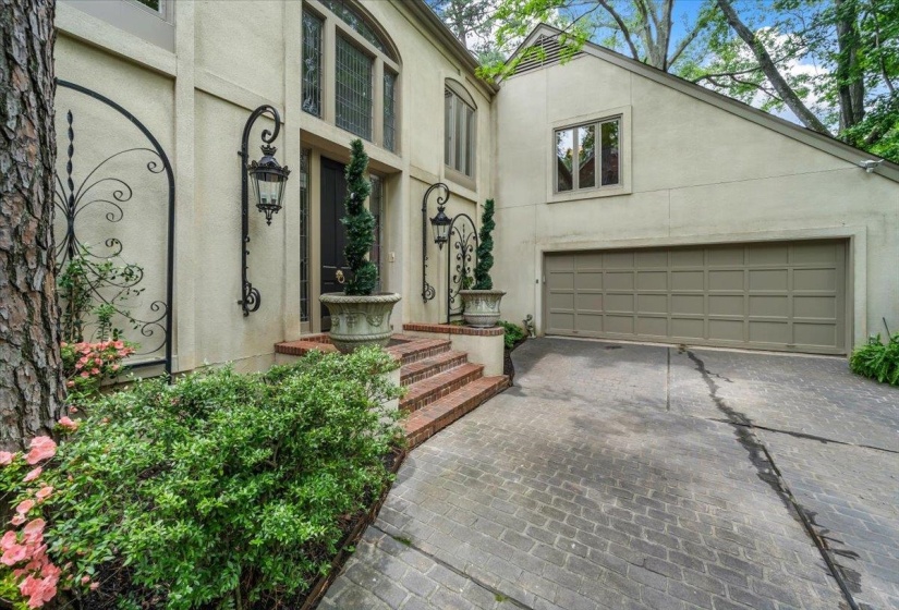 View of front of home with stucco siding, a garage, and driveway