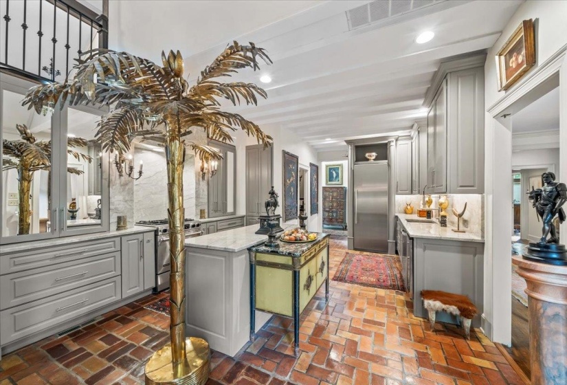 Kitchen featuring gray cabinets, premium appliances, a kitchen island, brick flooring, and decorative backsplash