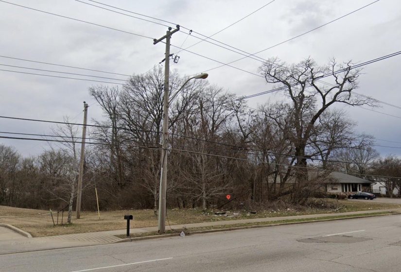 View of asphalt street with curbs, sidewalks, and street lights