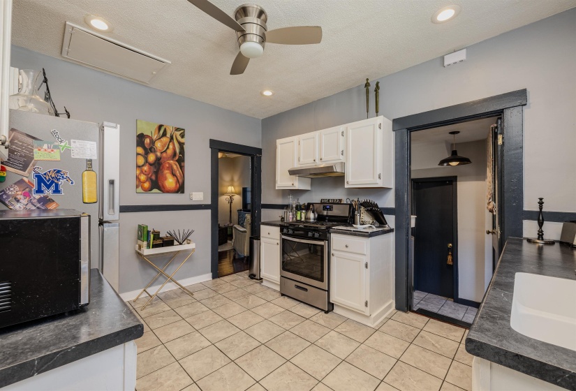 Kitchen with gas range, dark countertops, under cabinet range hood, a ceiling fan, and recessed lighting