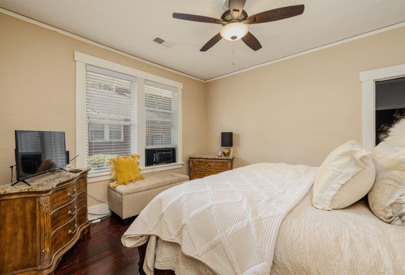 Bedroom with dark wood finished floors, ornamental molding, cooling unit, ceiling fan, and baseboards