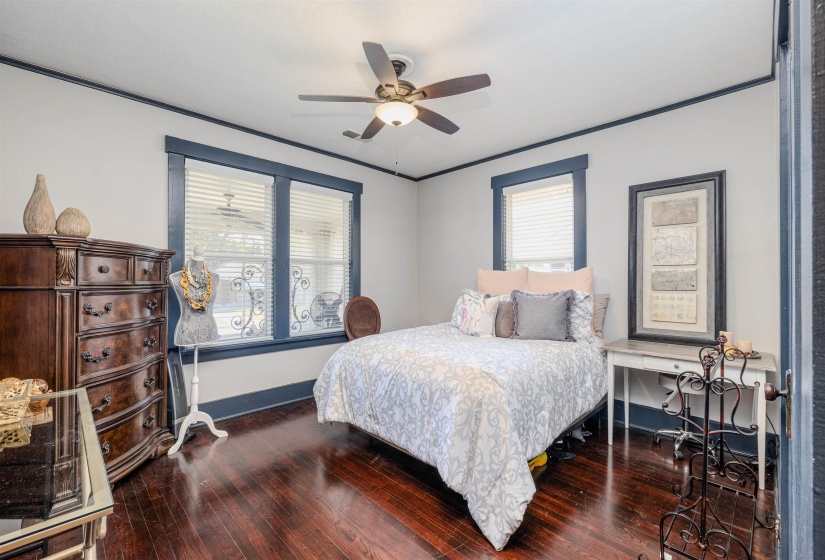 Bedroom featuring hardwood / wood-style flooring, baseboards, ceiling fan, and ornamental molding