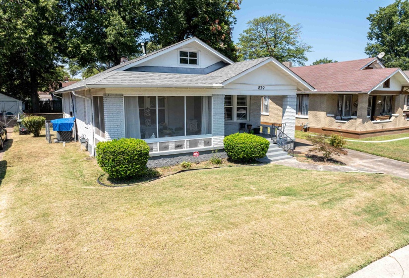 View of front of house featuring brick siding, a front yard, covered porch, and a shingled roof