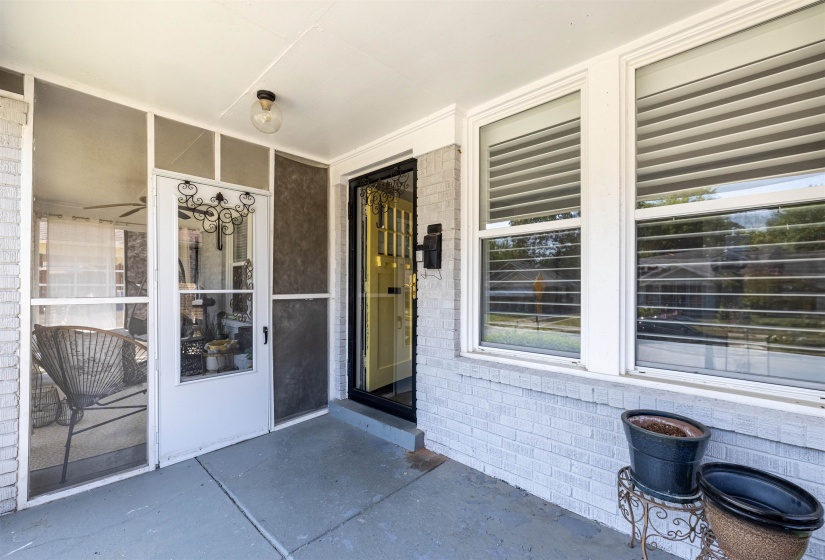Entrance to property with brick siding and a porch