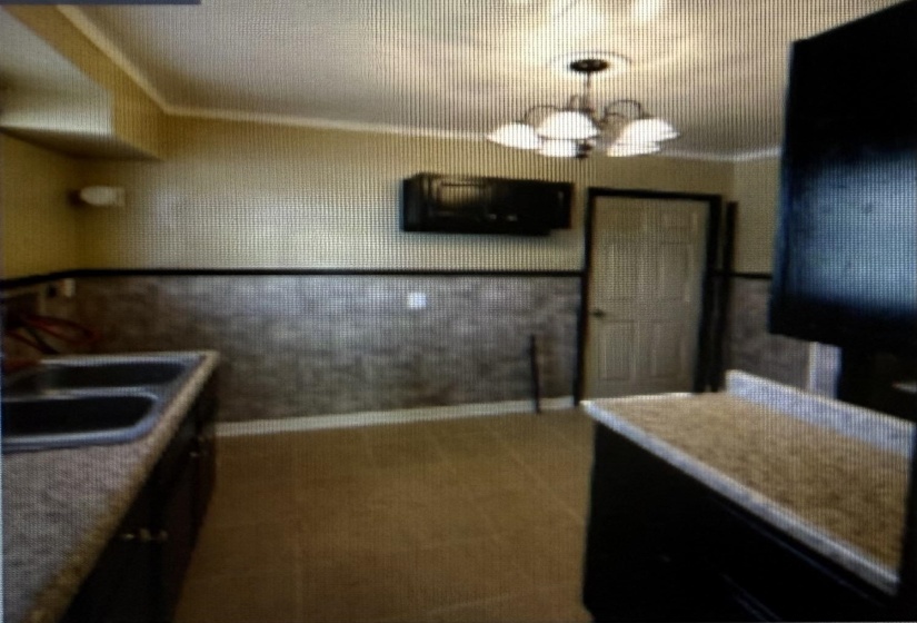 Kitchen featuring a chandelier and carpet
