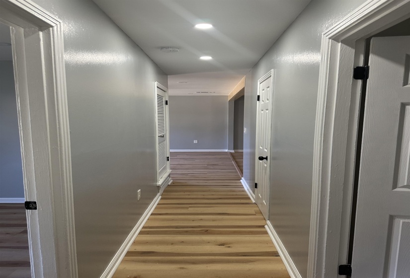 Corridor featuring light wood finished floors, baseboards, and recessed lighting