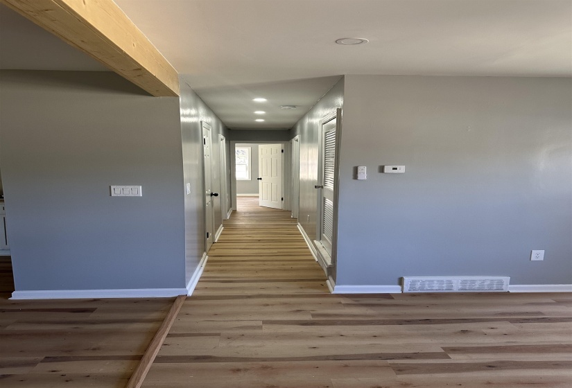Hallway featuring baseboards, visible vents, wood finished floors, and recessed lighting