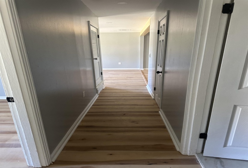 Hallway with baseboards and light wood-style floors