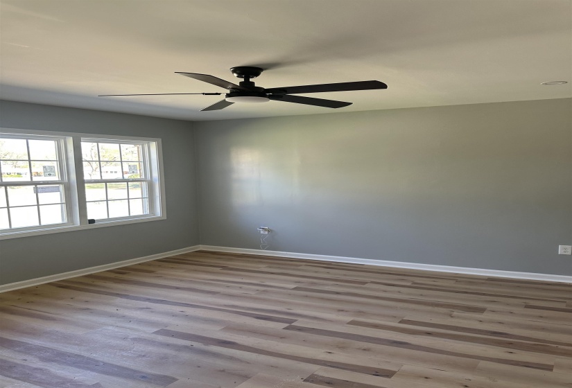 Spare room featuring baseboards, wood finished floors, and a ceiling fan