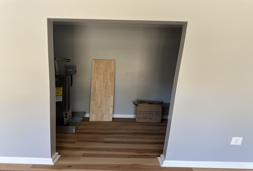 Interior space with water heater, baseboards, and wood finished floors