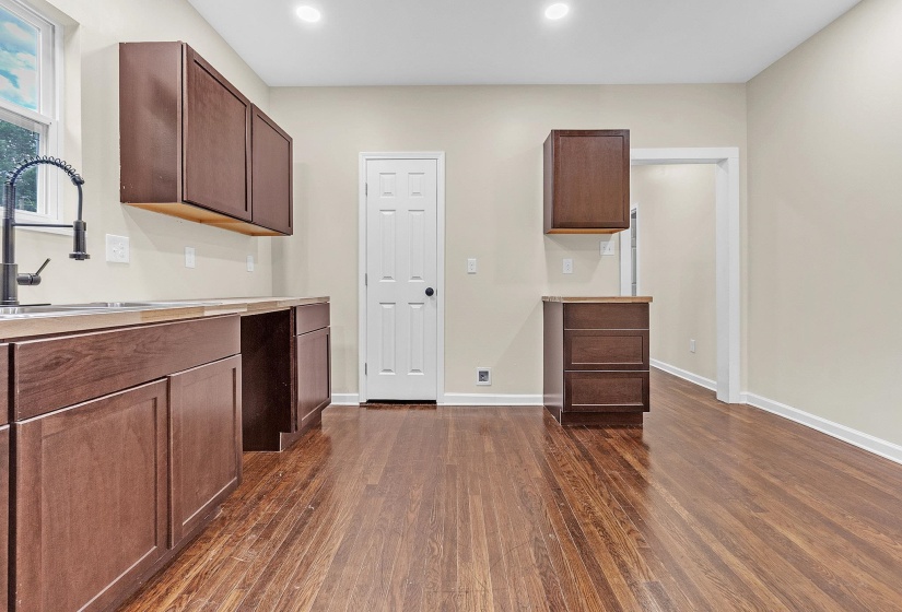 Kitchen with dark wood-type flooring, a sink, light countertops, baseboards, and recessed lighting