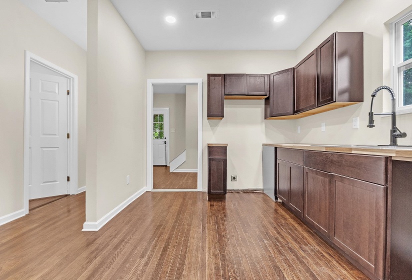 Kitchen featuring dark wood finished floors, healthy amount of natural light, dark brown cabinetry, light countertops, and recessed lighting