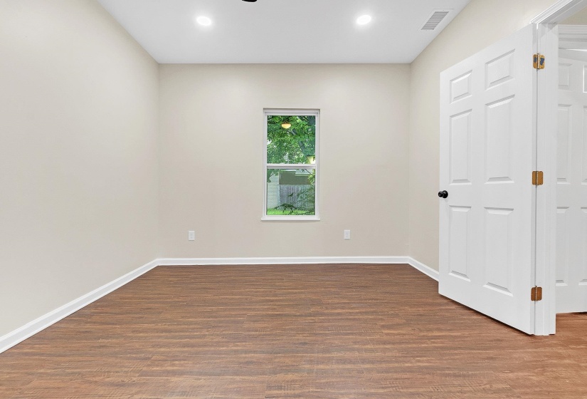 Unfurnished room featuring dark wood-style floors, baseboards, and recessed lighting