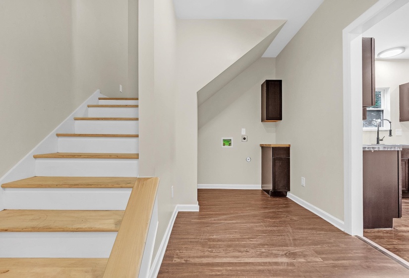 Staircase with wood finished floors and baseboards