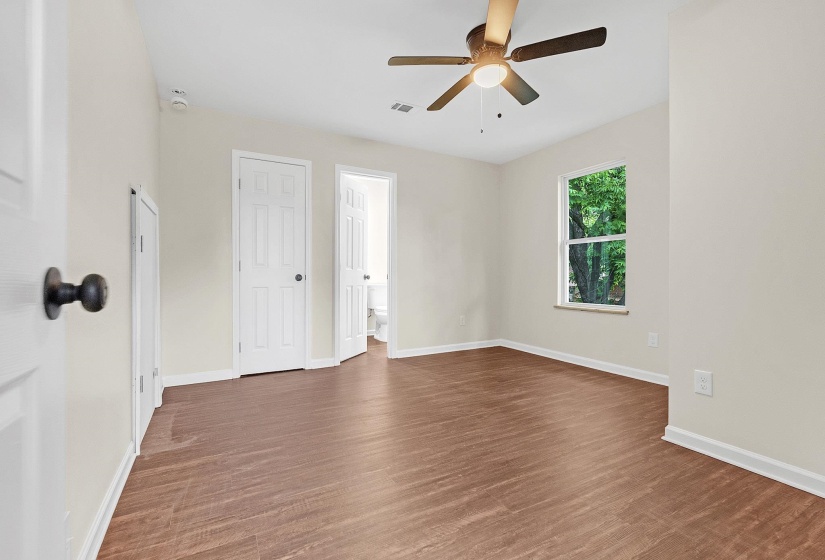 Empty room with a ceiling fan, wood finished floors, and baseboards