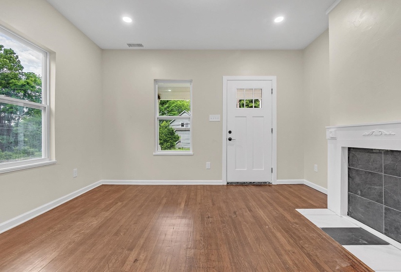 Entrance foyer with wood finished floors, plenty of natural light, a fireplace, baseboards, and recessed lighting