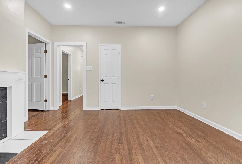Unfurnished room with a tiled fireplace, wood finished floors, baseboards, and recessed lighting