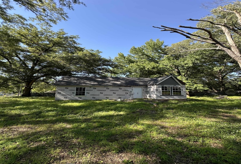 Rear view of house featuring a lawn