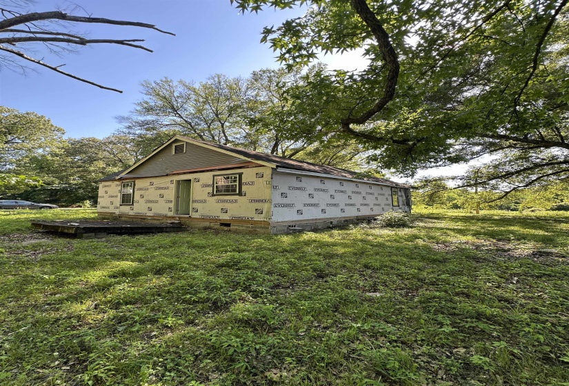 View of side of property with crawl space and a yard