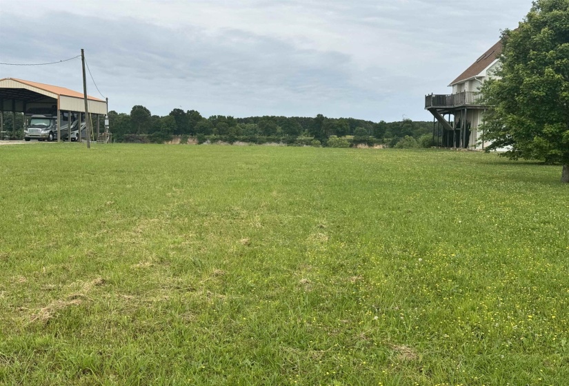 View of grassy yard with a detached carport