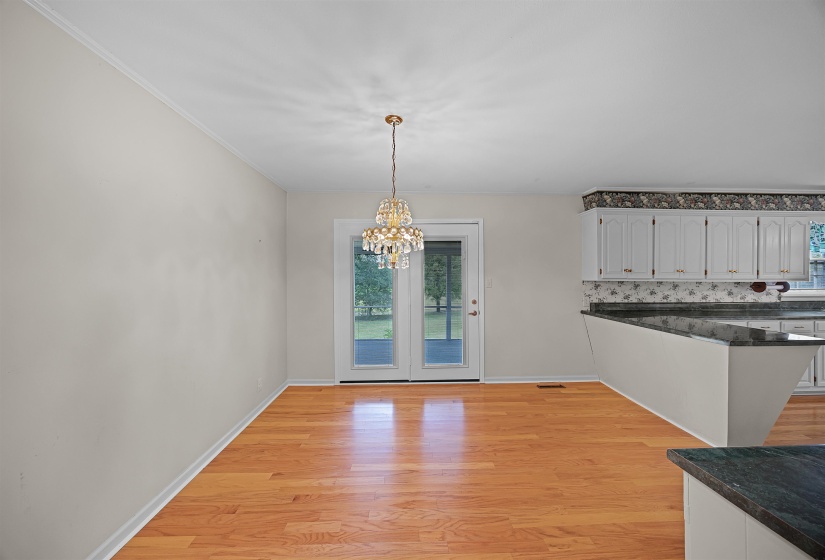Unfurnished dining area featuring a chandelier, light hardwood / wood-style flooring, and a wealth of natural light
