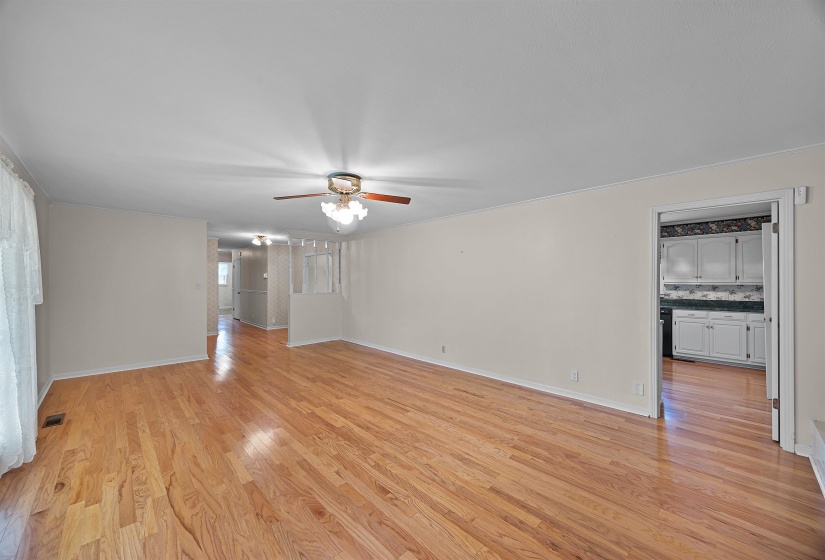 Empty room with light hardwood / wood-style floors and ceiling fan