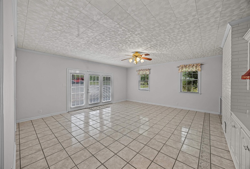 Tiled spare room with plenty of natural light and ceiling fan