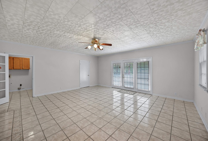 Tiled empty room featuring crown molding and ceiling fan