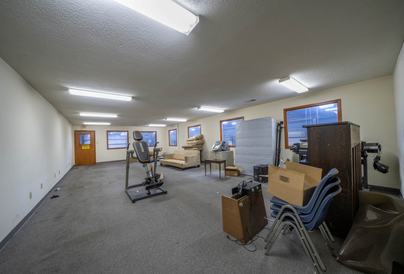 Workout room featuring a textured ceiling, baseboards, and carpet floors